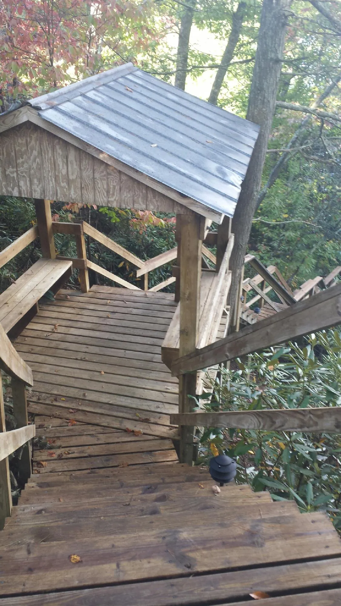 Metal roofed shelter over wooden steps on a wooded walkway — Skylight Repair & Installation work by our crew in Klamath River