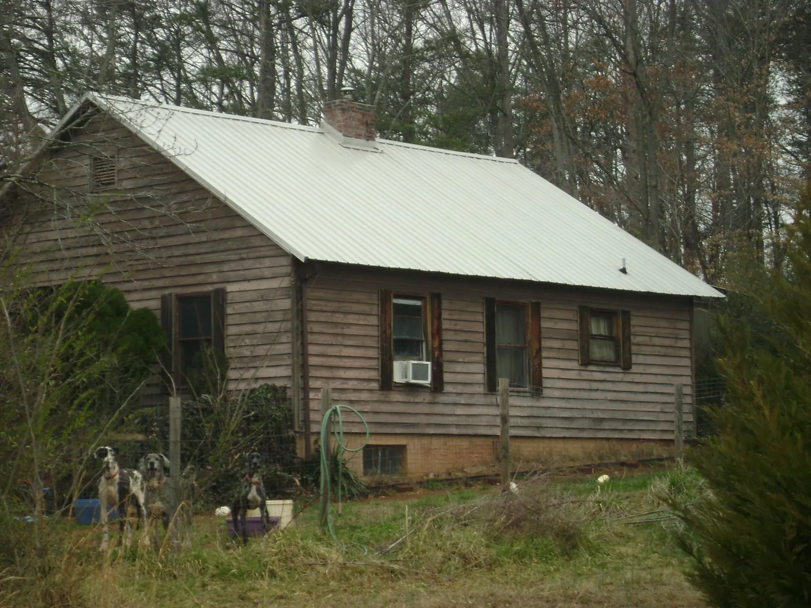 White metal roof on an old wood sided farmhouse, from a Metal Roof Installation job in Klamath River